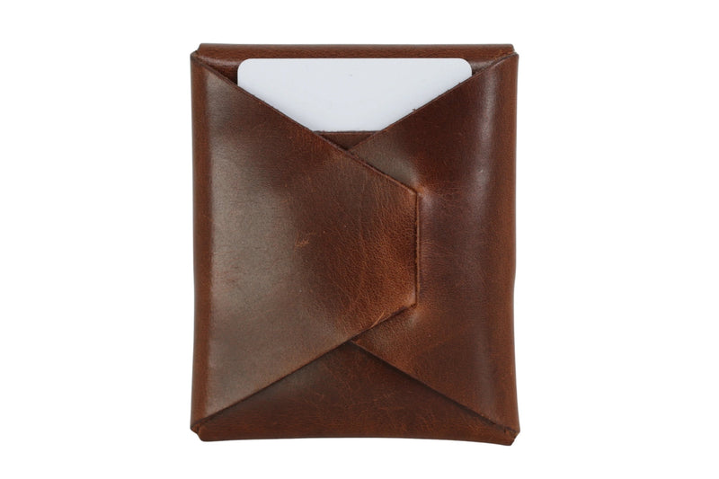 Flint stitchless full grain leather card holder in Dublin Tan with a card in the diagonal fold, showing folded construction and no stitch line