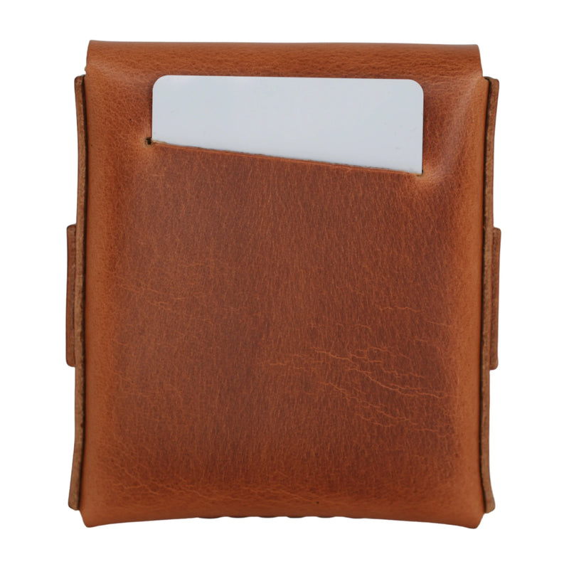 A card being slipped into the front pocket of a closed camel full grain leather strap wallet