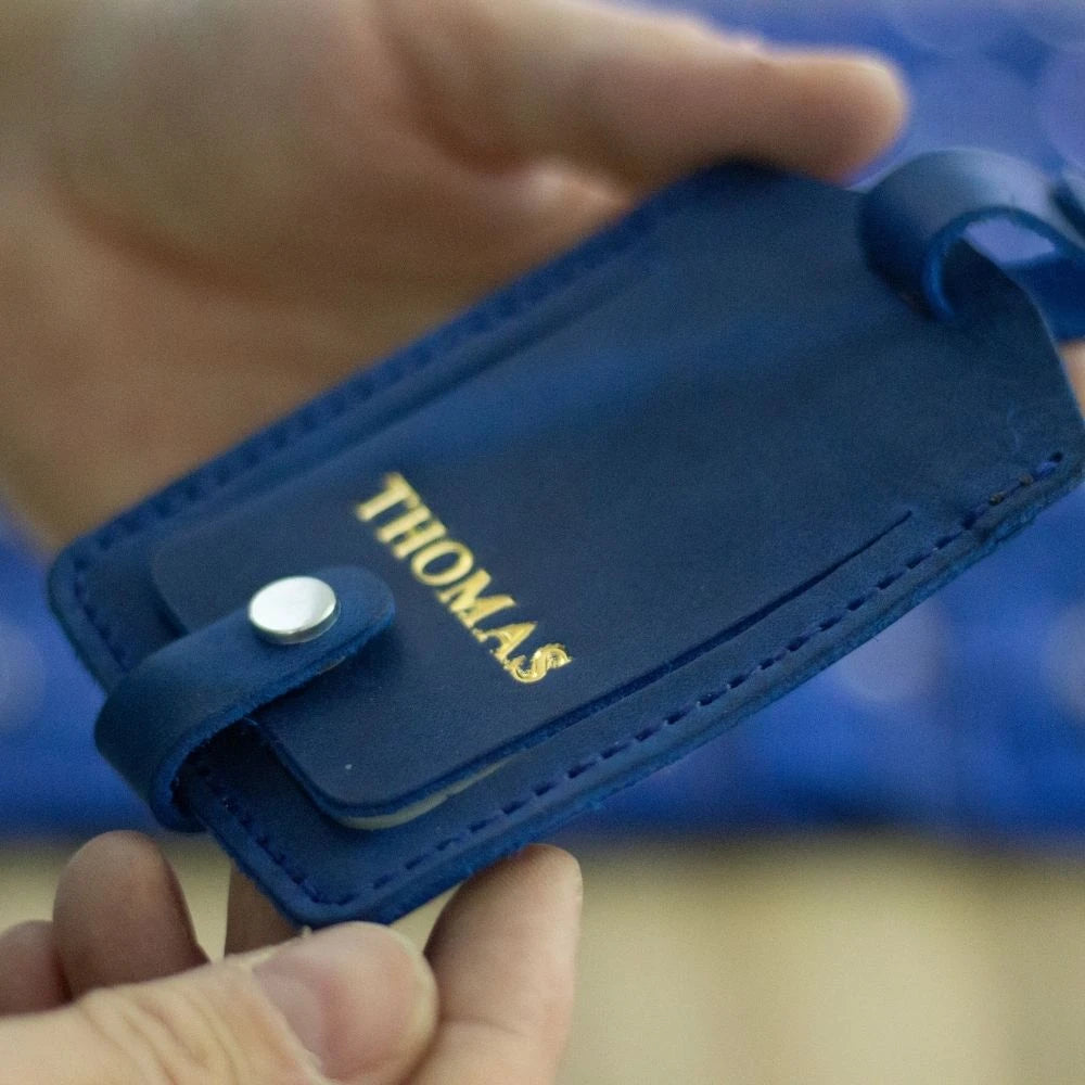 Blue leather luggage tag from personalized leather accessories collection.