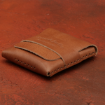 Brown leather wallet on a red-brown textured surface 