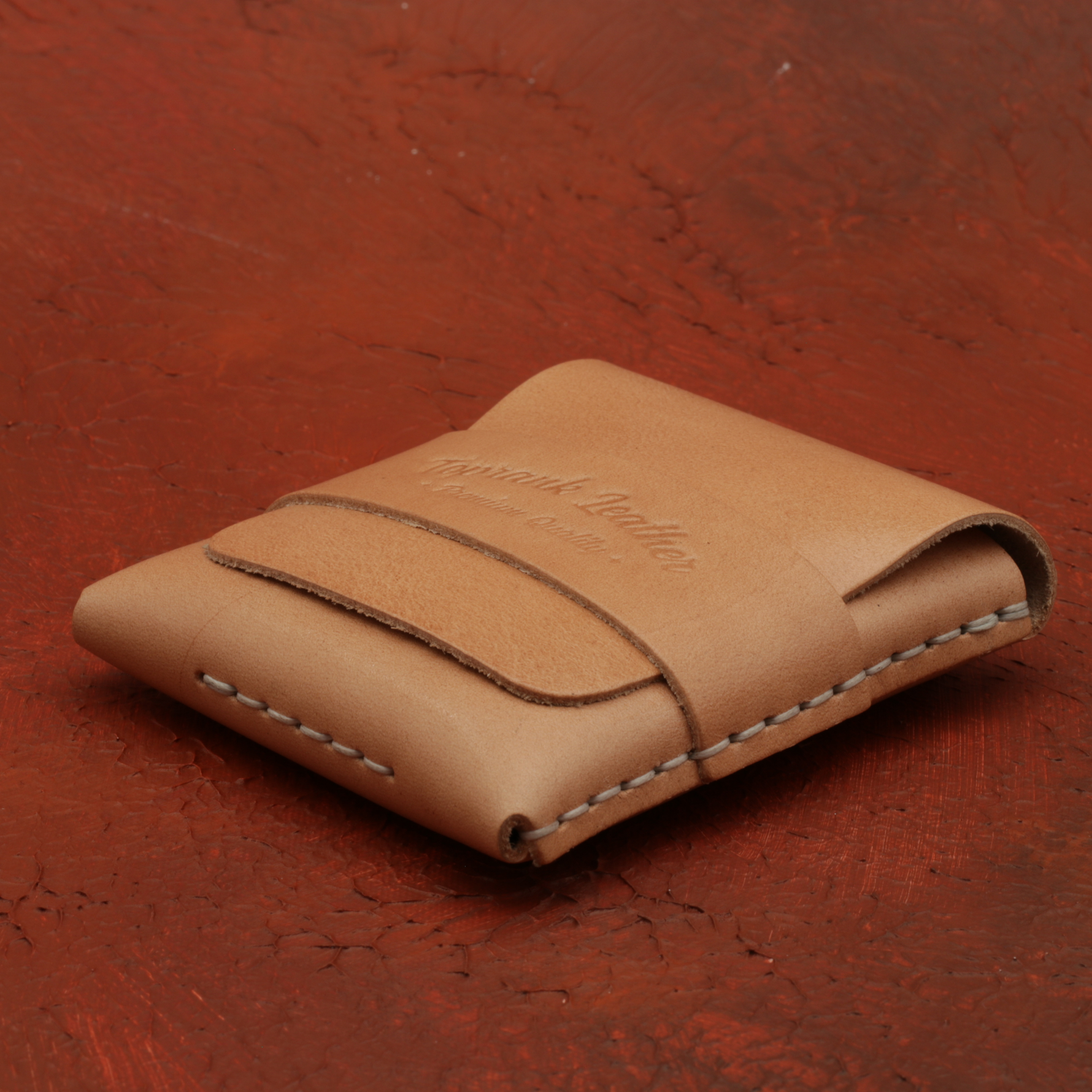 Brown leather wallet on a red textured surface 