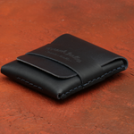 Navy Blue leather wallet with branding on a brown surface 