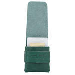 Green leather case with a white interior holding a gold item on a white background 