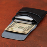Two-tone wallet with money and cards on a wooden surface 