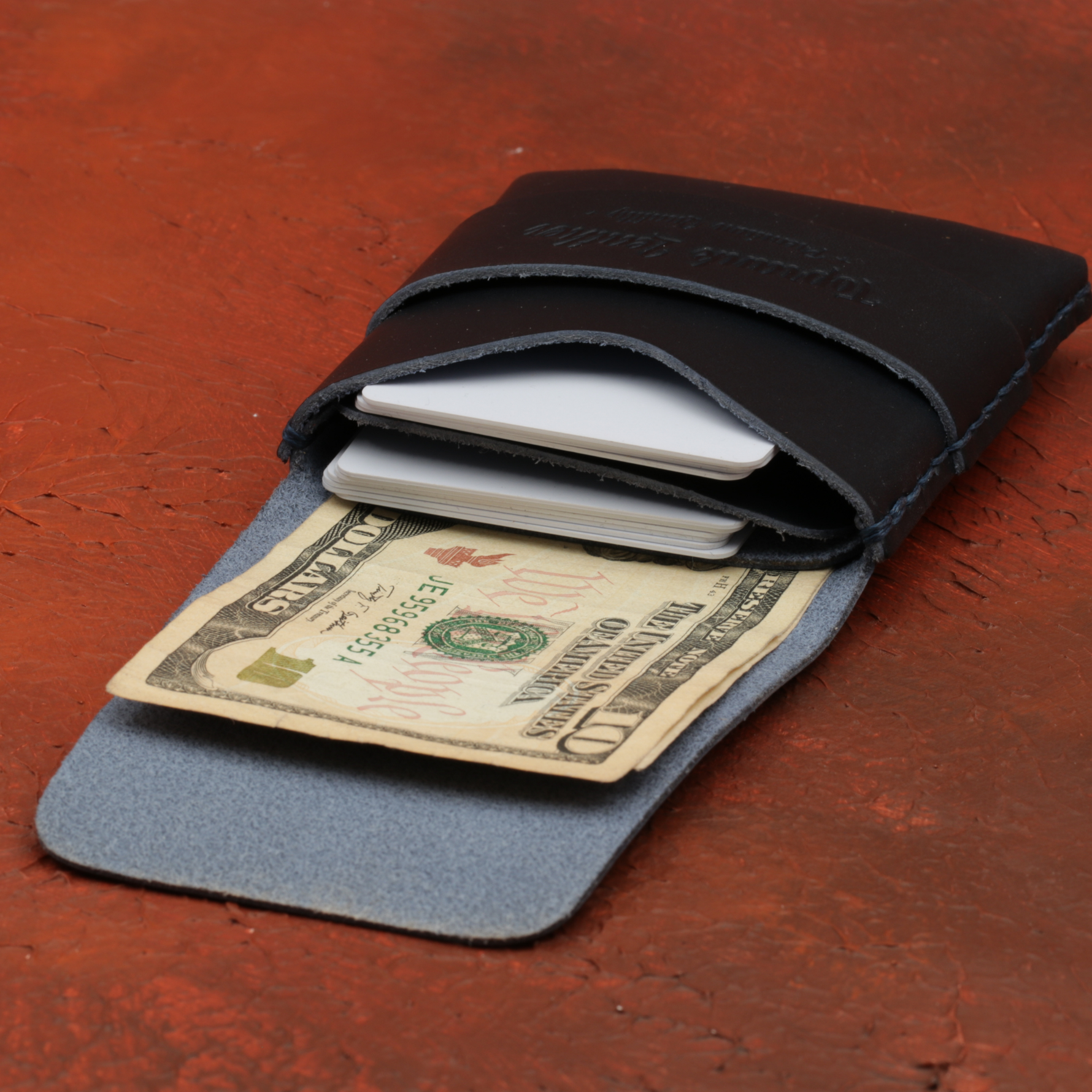 Two-tone wallet with money and cards on a wooden surface 