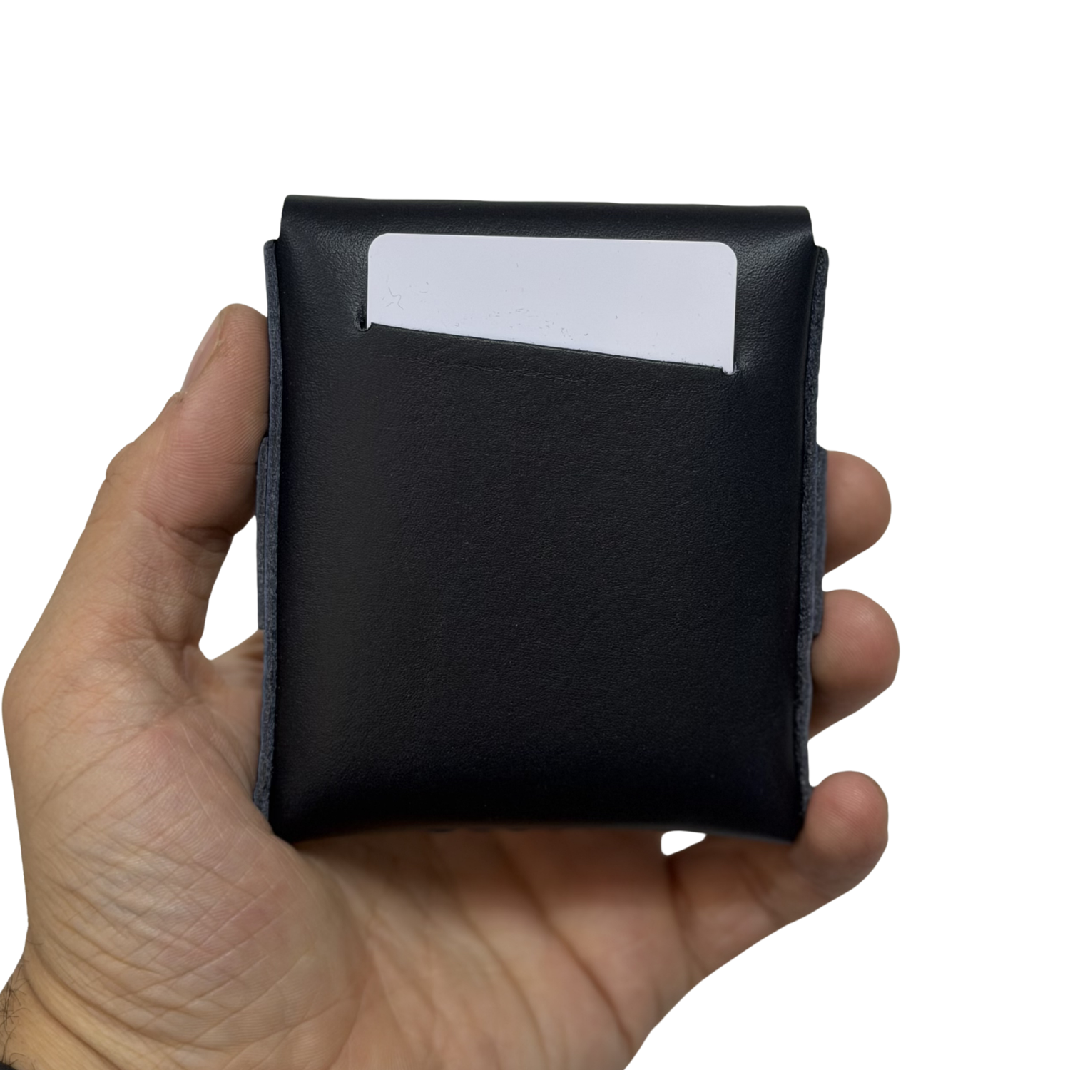Hand holding a black leather wallet with a white card inside on a white background