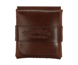 A dark brown leather card holder or small wallet with a strap closure embossed with the brand name 'Torano's Leather' and 'Premium Quality', shown on a plain white background. 