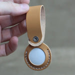 Tan leather Airtag holder with secure snap-button closure in handcrafted full-grain leather