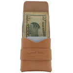 Brown leather money clip with a dollar bill inside on a white background 