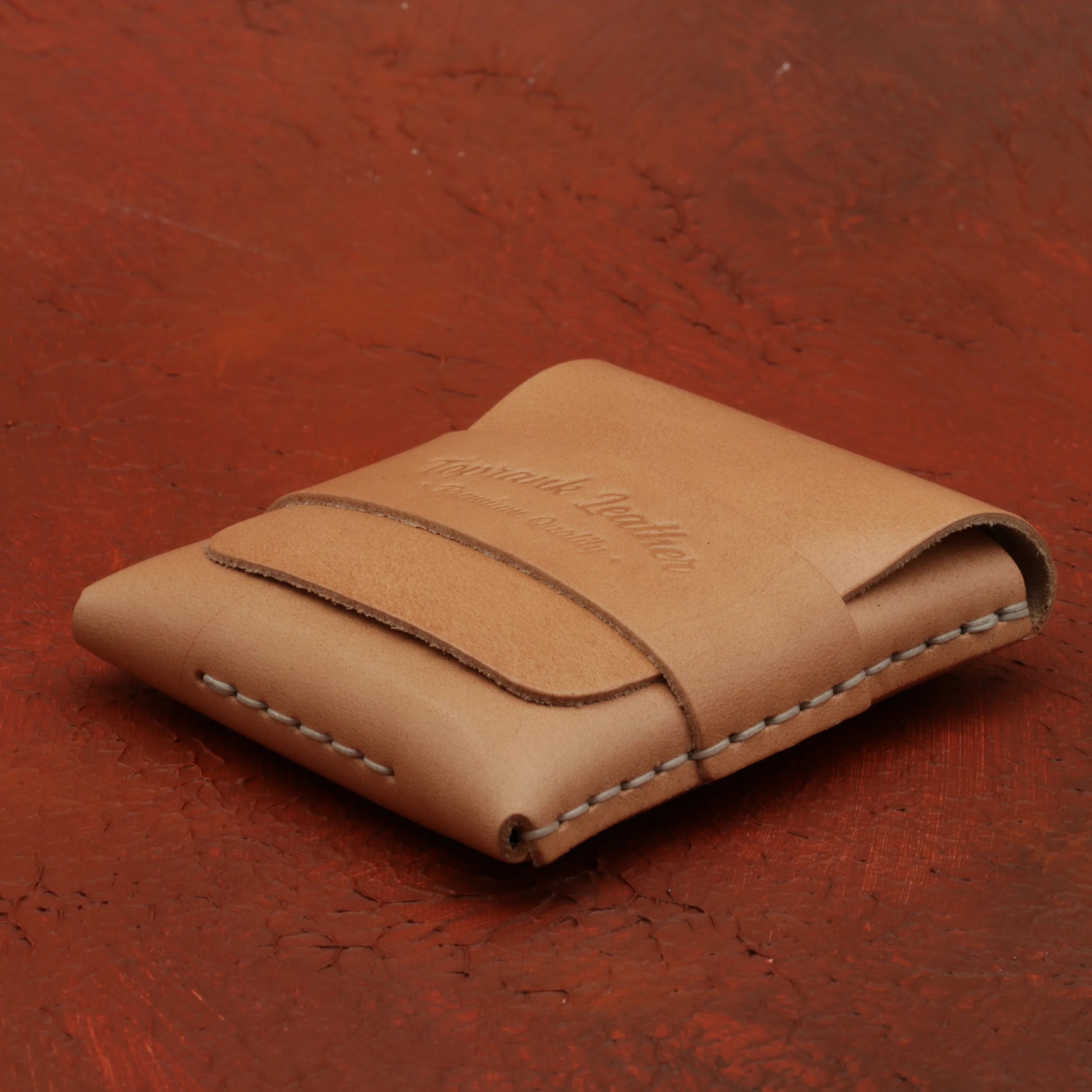 Brown leather wallet on a red textured surface 
