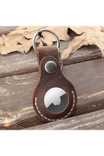 Brown leather keychain with a metallic ring on a wooden surface 