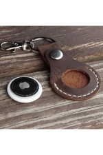 Brown leather keychain with a metal clasp on a wooden surface 