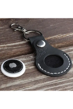 Black leather keychain with a metal clasp on a wooden surface 