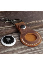 Brown leather keychain with a metal clip on a wooden surface 