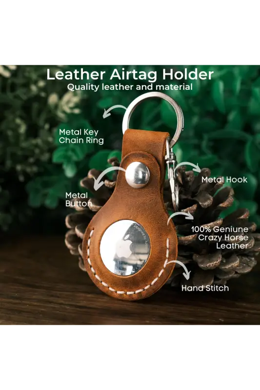 Leather airtag holder with keychain ring on a wooden surface with greenery in the background 