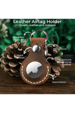 Leather airtag holder with keychain features on a wooden surface with greenery in the background 