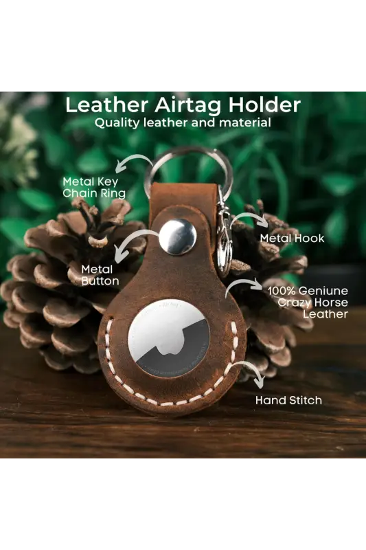 Leather airtag holder with keychain features on a wooden surface with greenery in the background 