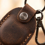 Brown leather keychain with metal clip on a blurred background 