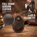 Brown leather keychain with magnifying glass highlighting full-grain leather, and text about snug fit. 