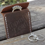 Brown leather wedding ring case displaying rings for elegant jewelry storage