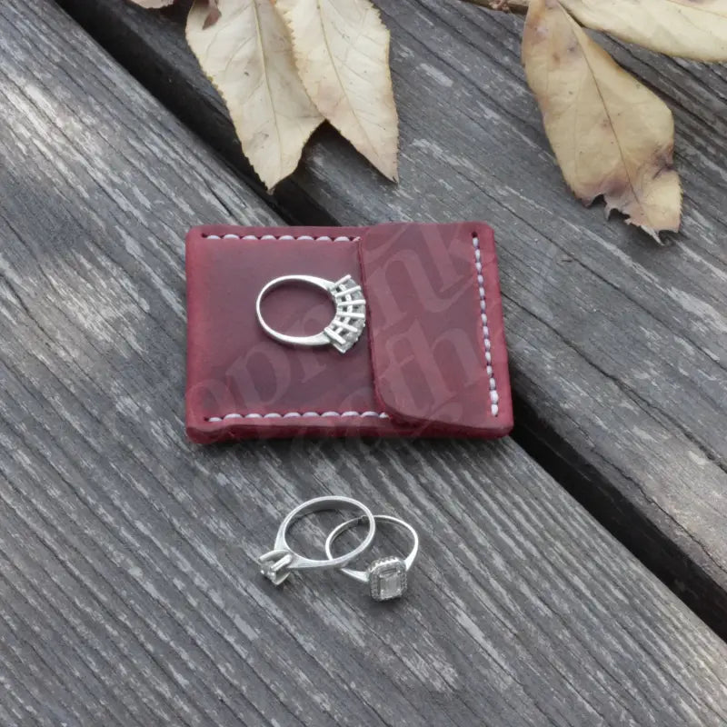 Burgundy leather wedding ring case with white stitching for elegant jewelry storage