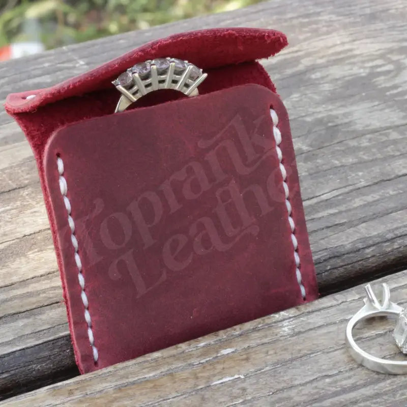 Burgundy leather wedding ring case with white stitching for elegant jewelry storage