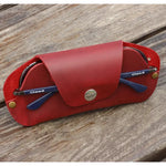 Red leather eyeglass case with blue glasses for stylish protection and portability