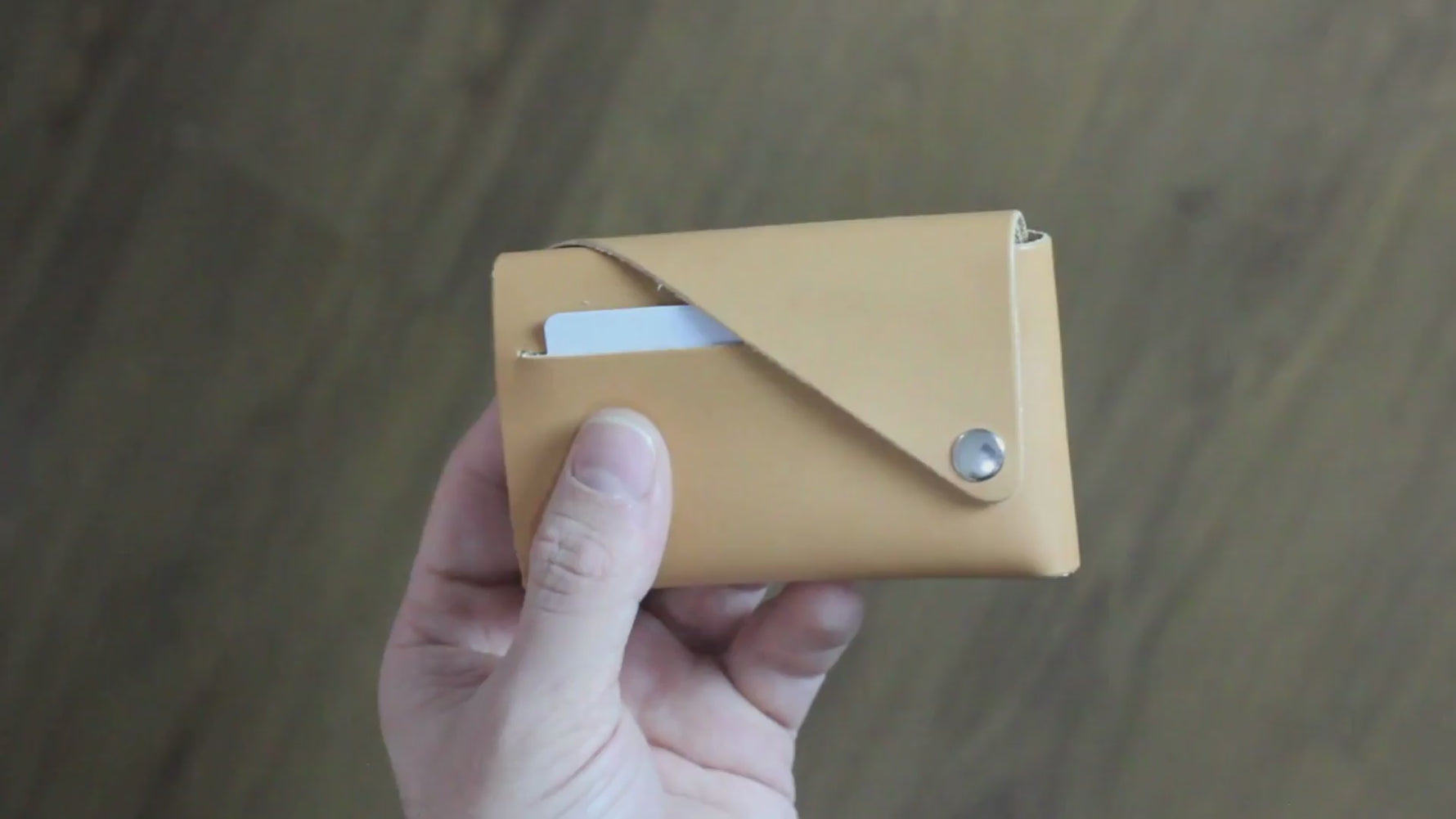 A close-up video showcasing the Two-Access Leather Wallet, highlighting its minimalist design, premium full-grain vegetable-tanned leather, and innovative stitch-free construction.