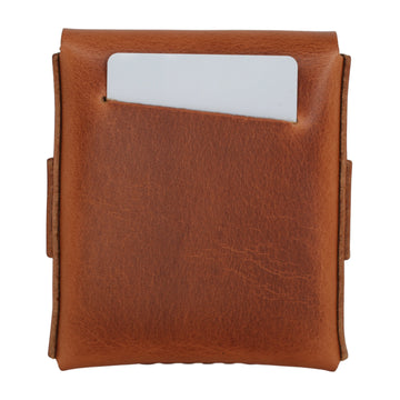 A brown leather card holder wallet with a white card partially inserted into a front slip pocket, shown against a plain white background. 