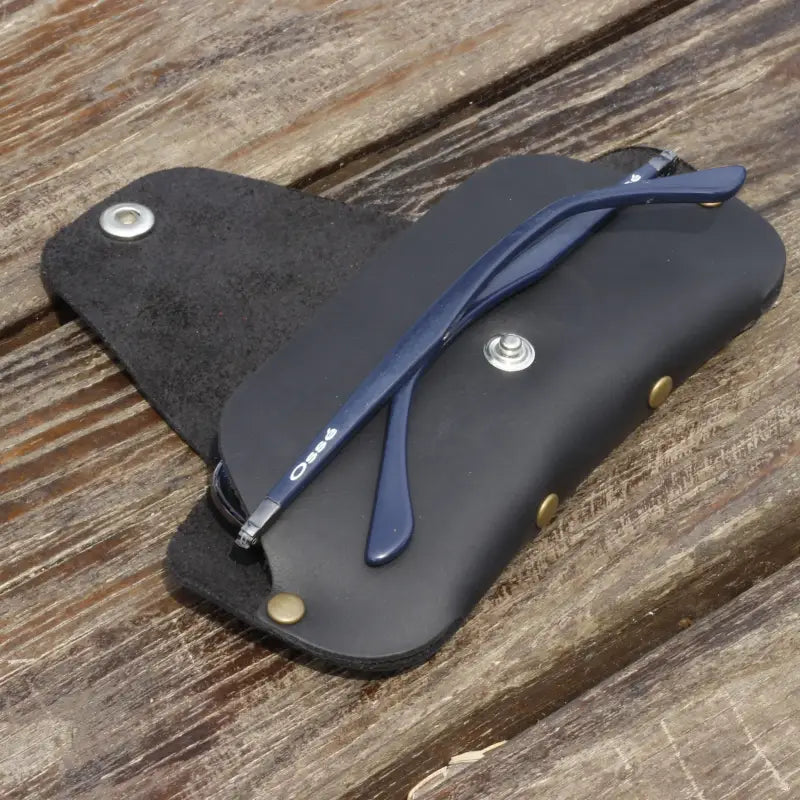 Blue eyeglasses in a Slim Leather Eyeglass Case with a black leather exterior